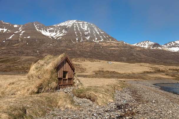 Small wooden house with grass roof in the Iceland fjord - Fotografie, Obrázek