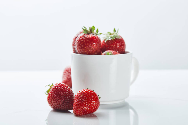 ripe sweet strawberries in cup on white background - Foto, afbeelding