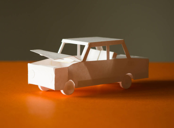 The paper model of the car got into an accident and got damaged. Car accident concept - Zdjęcie, obraz