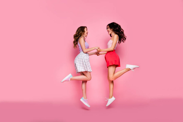 Full length body size profile side view portrait of nice-looking smart attractive charming lovely careless cheerful cheery girls having fun day time isolated over pink pastel background - Photo, image