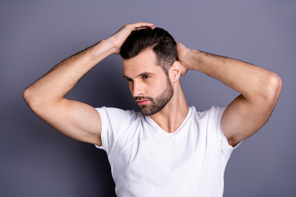 Close up photo amazing he him his macho perfect appearance touch arm hand neat groomed head haircut calm not smiling look mirror bath empty space wear casual white t-shirt isolated grey background - Foto, Bild