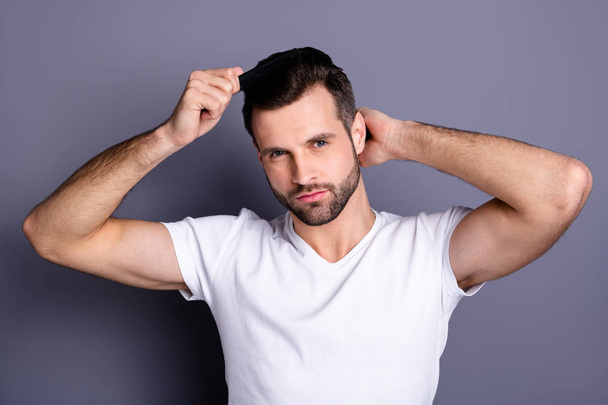 Close up photo amazing he him his macho perfect appearance hands arms plastic hair styling brush take care hairdo after barber shop stylist visit wear casual white t-shirt isolated grey background - Foto, Imagem