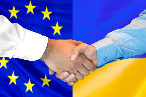 poignée de main sur fond de drapeau de l'Union européenne et de l'Ukraine
. - Photo, image