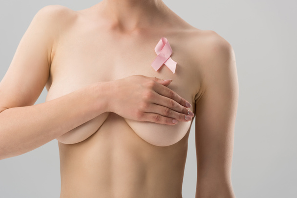 cropped view of naked young woman with pink ribbon isolated on grey - Fotoğraf, Görsel