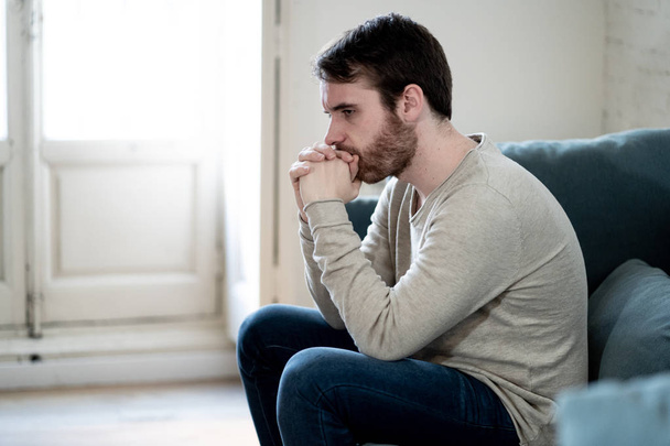 Unhappy depressed caucasian male sitting and lying in living room couch feeling desperate a lonely suffering from depression. In stressed from work, anxiety, heartbroken and men Health care concept. - Foto, Bild