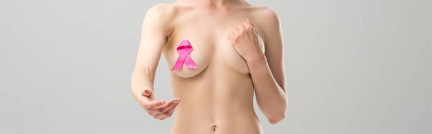 灰色に隔離された伸びた手を持つピンクのリボンを持つ裸の女性のパノラマショット - 写真・画像