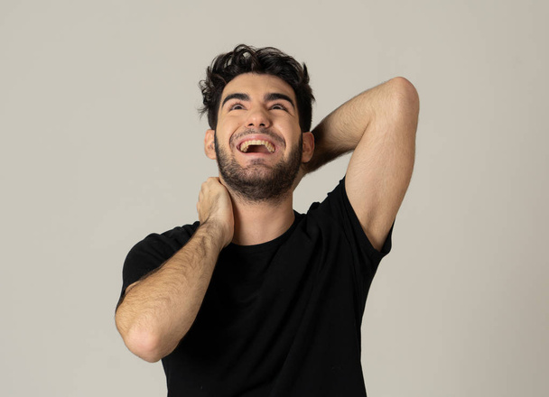 Positive human facial expressions and emotions. Portrait of handsome young male in his 20s with happy face smiling and making cheerful gestures at the camera. Close up Isolated on neutral background. - Valokuva, kuva