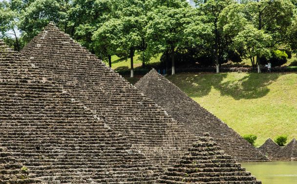 kivi materiaali pyramidi jäljitelmä rakennuksen puutarha julkisivu näkymä
 - Valokuva, kuva