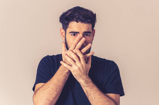 Young man feeling scared and shocked making fear anxiety gestures. Looking terrified and desperate trying to cover himself. Portrait with copy space. People and Human expressions and emotions. - Foto, imagen