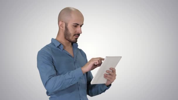 Handsome arabic business man using tablet on gradient background. - Metraje, vídeo