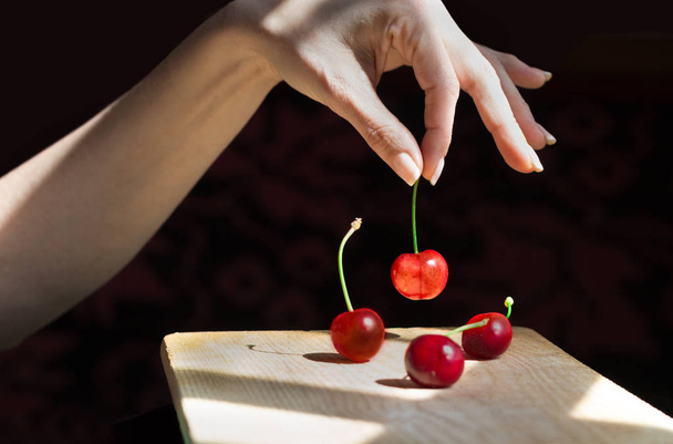 Female hand selecting a cherry - Photo, Image