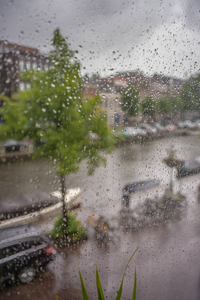 Blick aus dem Fenster auf Kanal und Straße während des Sturms - Foto, Bild