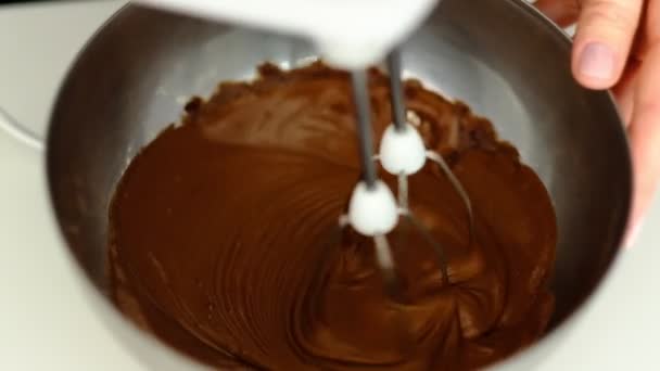 Macro, Slow Motion, mixer. Klop het deeg van de chocoladetaart in de kom van glas. - Video