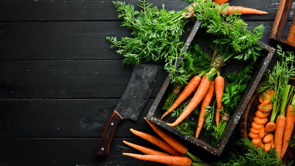 Fresh carrots on a black wooden background. Top view. - Photo, Image