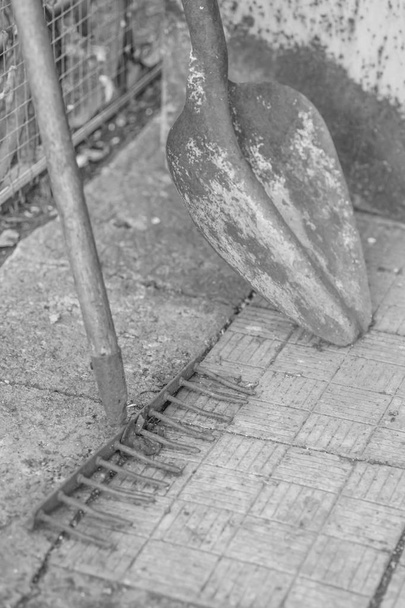 Vieille bêche rétro et râteau sur le sol de la cour carrelage
.  - Photo, image