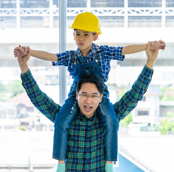 Construtor pai está carregando seu filho em seu pescoço para o pai filho su
 - Foto, Imagem