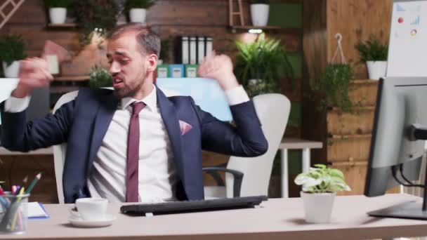 Male business person in formal suit starts dancing at his desk - Materiał filmowy, wideo