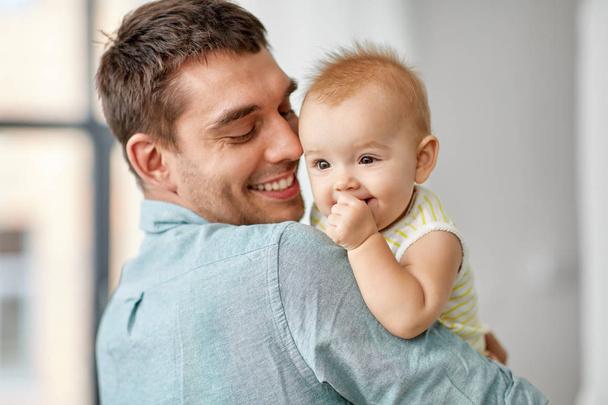 happy father holding little baby daughter at home - Фото, изображение