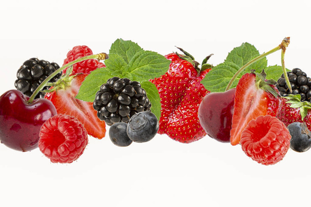 Assorted berries isolated on white background.Cherry,blueberry,raspberry, mulberry and mint leaves . Summer harvest - Foto, imagen