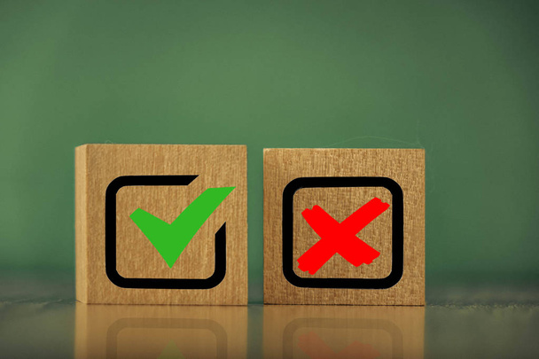 wooden cubes with the image of check marks marks on a green background. - Photo, Image