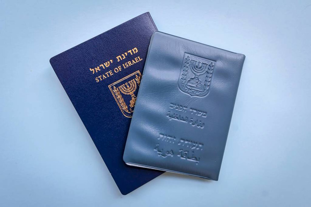 Documentos oficiales israelíes: pasaporte de Israel y documento de identidad nacional sobre un fondo azul claro con una pequeña bandera de Israel. Israel concepto de ciudadanía
 - Foto, Imagen