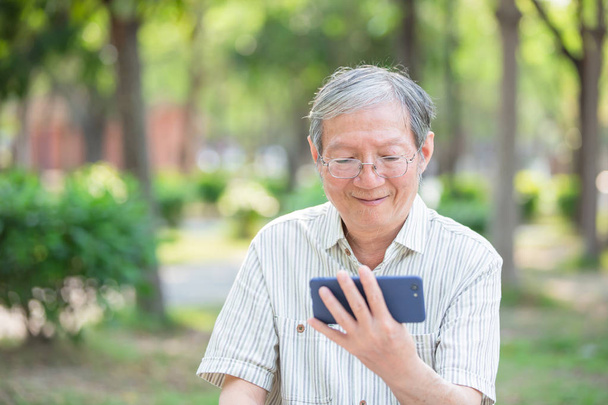 Older man watch video by cellphone - 写真・画像
