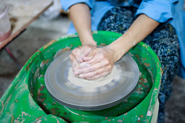Студент-початківець на першому уроці гончарства намагається зробити продукт з глини на гончарному колесі. репортаж. цензура з глини. Неправильний параметр руки
 - Фото, зображення