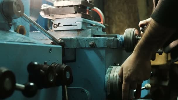 munkavállaló kéz forog fém eszterga kerek kar köszörülés részleteit - Felvétel, videó