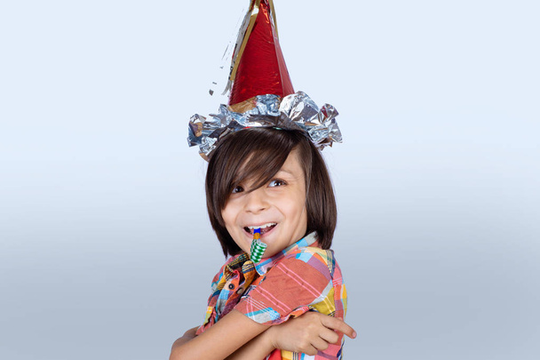 Little boy wearing a party hat. - Фото, изображение