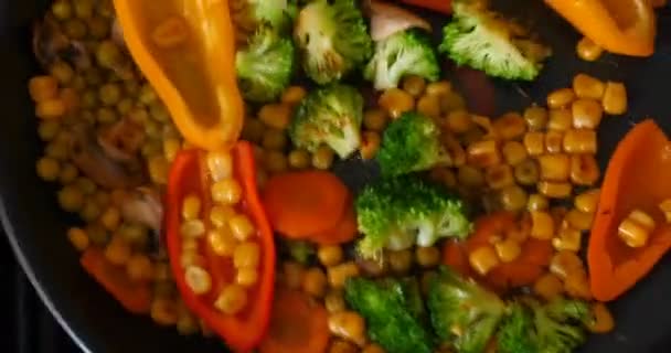 Delicious fresh vegetables are stewed in a pan, food for vegetarians at home. Concept of: Veg, Bio Product, Mushrooms, Broccoli, Colored Cabbage, Carrot, Corn, Paprika. - Кадры, видео