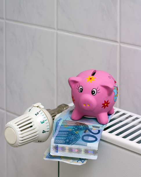 Piggy bank with radiator thermostat saving heating costs - Photo, Image
