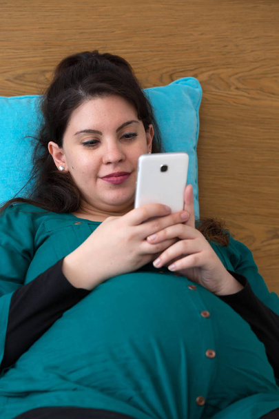 Expectant Young Mom Searching on Her Smartphone - Foto, Imagen