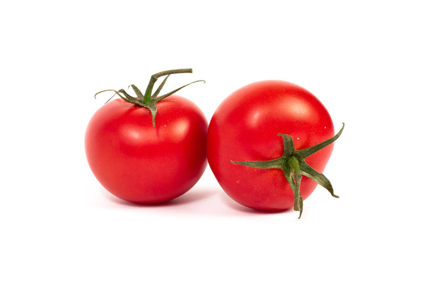 Red tomatoes on a white background. A group of tomatoes with herbs on a white background. - 写真・画像