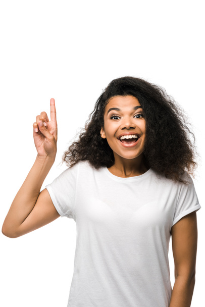 femme afro-américaine souriante en t-shirt blanc pointant du doigt isolé sur blanc
  - Photo, image
