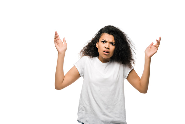 роздратована кучерява афроамериканська дівчина в білій футболці жестикулює ізольовано на білому
  - Фото, зображення