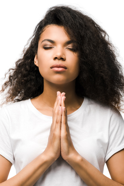  giovane donna afroamericana con gli occhi chiusi e le mani in preghiera isolate su bianco
  - Foto, immagini