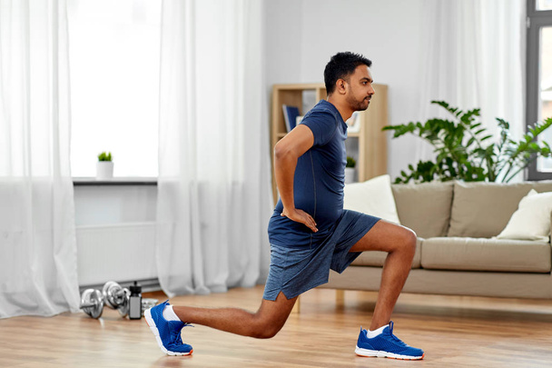 indian man exercising and doing lunge at home - Foto, afbeelding