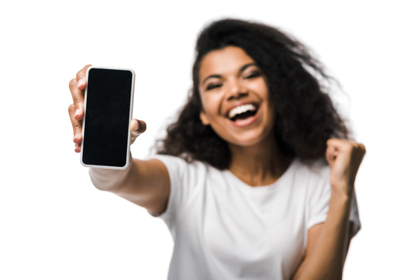 messa a fuoco selettiva di felice ragazza afro-americana che tiene smartphone con schermo bianco e celebra isolato su bianco
  - Foto, immagini
