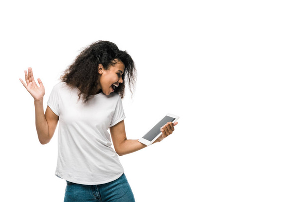 happy african american girl looking at digital tablet and gesturing isolated on white  - Fotografie, Obrázek