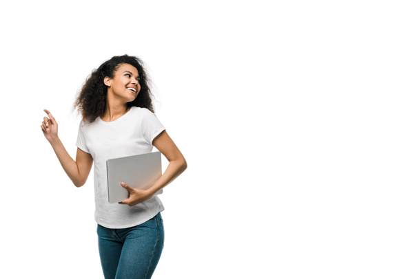 allegra giovane donna afro-americana gesticolando mentre teneva il computer portatile isolato su bianco
  - Foto, immagini