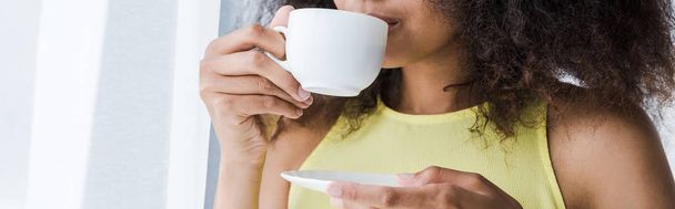 panoramic shot of african american woman drinking coffee from cup  - Fotoğraf, Görsel
