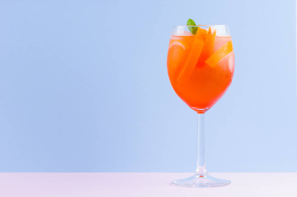 Cocktail Aperol Spritz on a blue pink background. Italian cocktail aperol spritz in pop art style. Summer trendy drink on pastel background - Photo, image