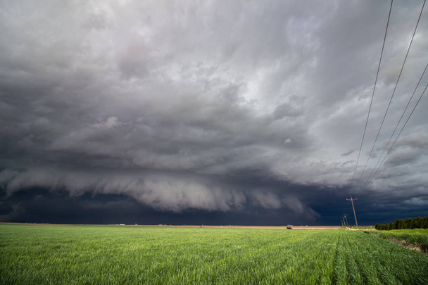 Una nube de estantería baja y una tormenta severa se aproximan rápidamente sobre el país agrícola
. - Foto, Imagen