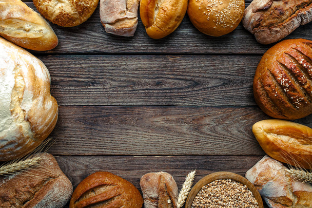 Assortment of baked bread on wooden table background,top view - Photo, Image