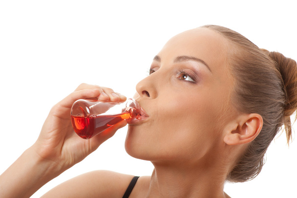 Woman drinking a red liquid - Zdjęcie, obraz