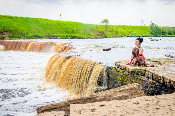 Woman on the waterfalls. Little waterfall. Camping. . Young woman. Woman in a dress. - 写真・画像