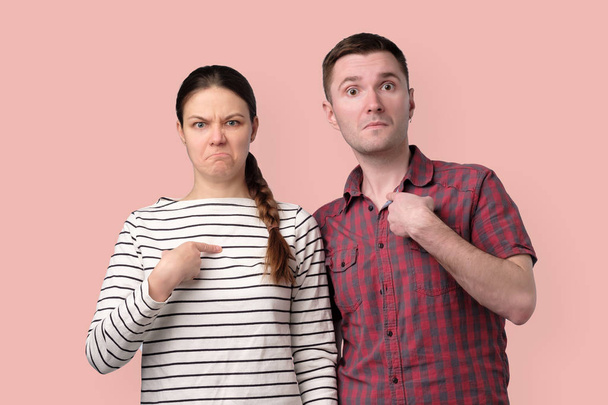 junges Paar zeigt mit dem Finger und hat zweifelhafte Gefühle - Foto, Bild