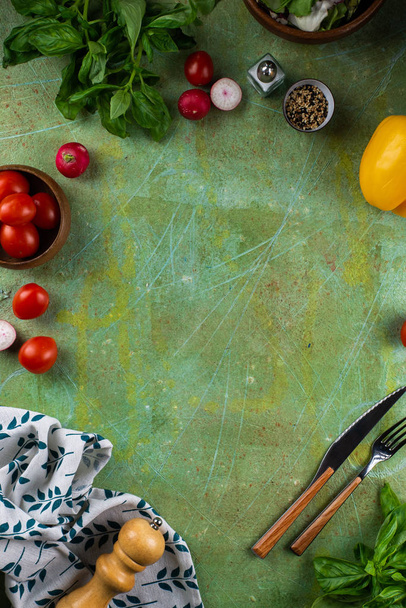 Shabby green tabletop with scattered fresh tomatoes, radishes and spices - Zdjęcie, obraz
