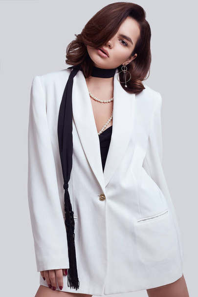 attraktive elegante Frau mit dunklen Haaren im modischen weißen Anzug - Foto, Bild