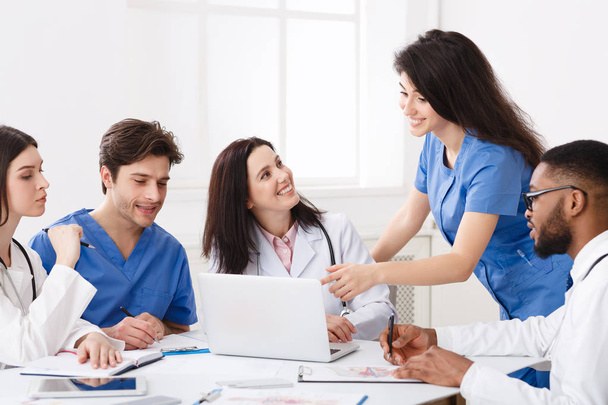 Команда практикующих врачей, изучающих медицинские отчеты на ноутбуке
 - Фото, изображение